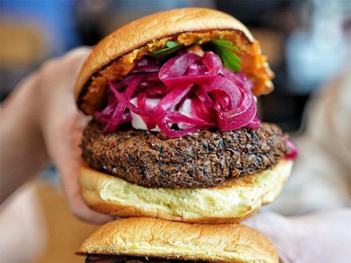 Close up of burger with red onion at our Hudson Square burger restaurant.