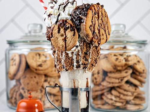 Close up view of the MSG Cookie Shake with jars of cookies behind it.