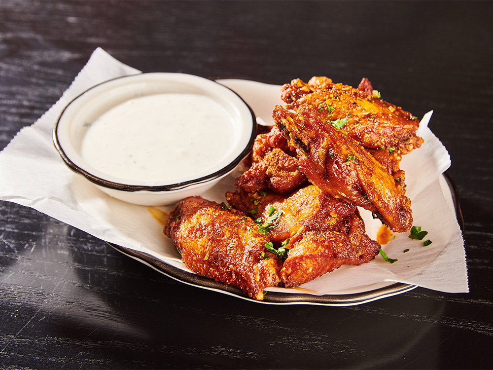 Hot Chili Wings on a plate with house buttermilk-dill, one of our Belmont-Hillsboro, Nashville wing delivery options.