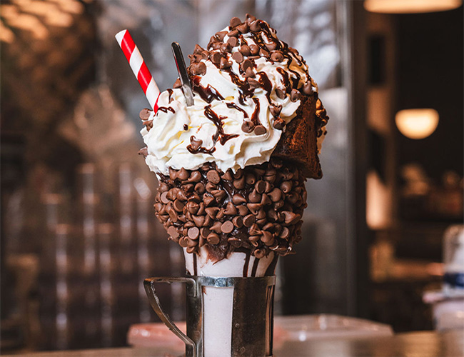 A milkshake with cake slice on top at our Bow, London shake bar.