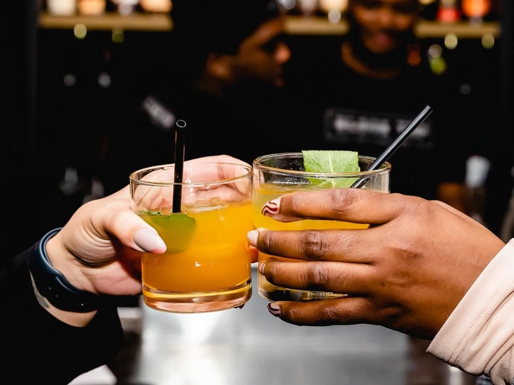 Two clinking cocktail glasses enjoyed as part of our Happy Hour food and drink specials near Midtown, Nashville, TN.